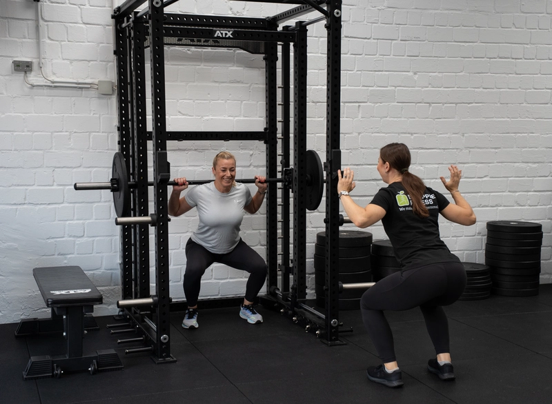 Personal Trainerin Iza Struck leitet eine Klientin an der Multipresse an
