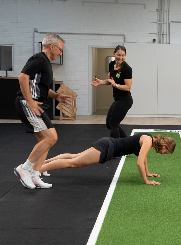 Personal Trainer Iza Struck leitet zwei Teilnehmer einer Gruppe an